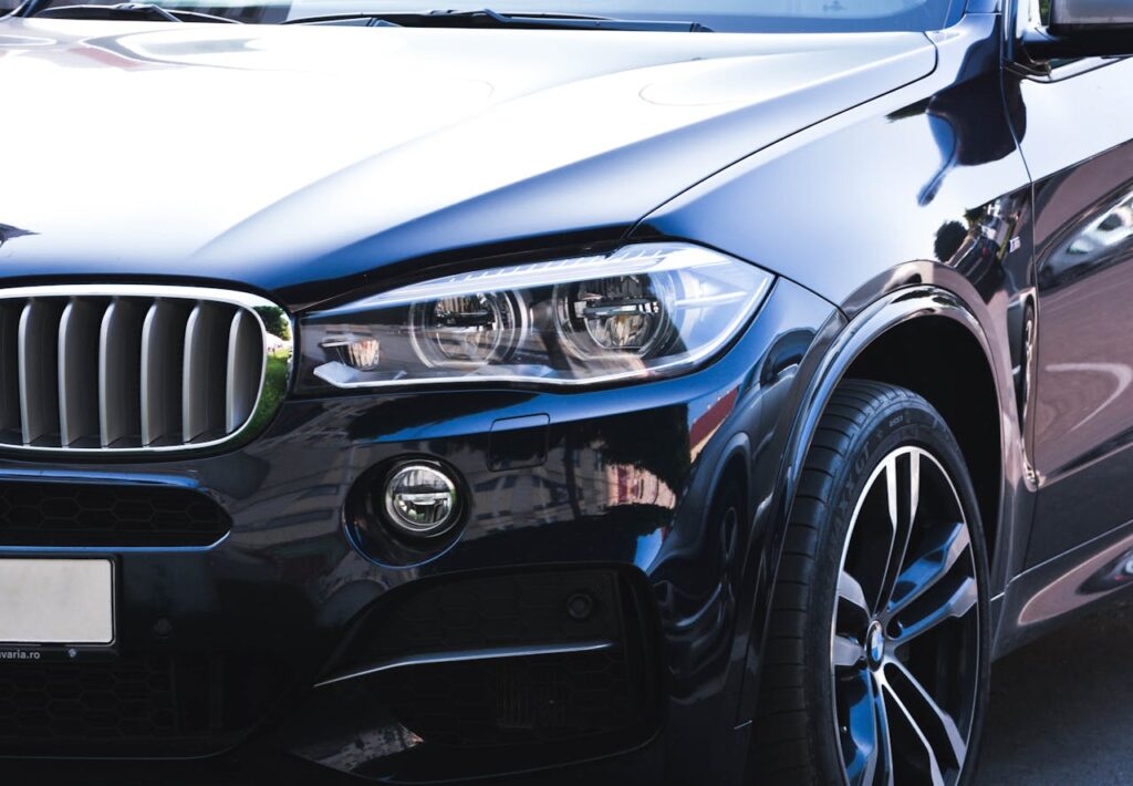 Close-up of a black luxury car showcasing intricate headlight and front grille details.