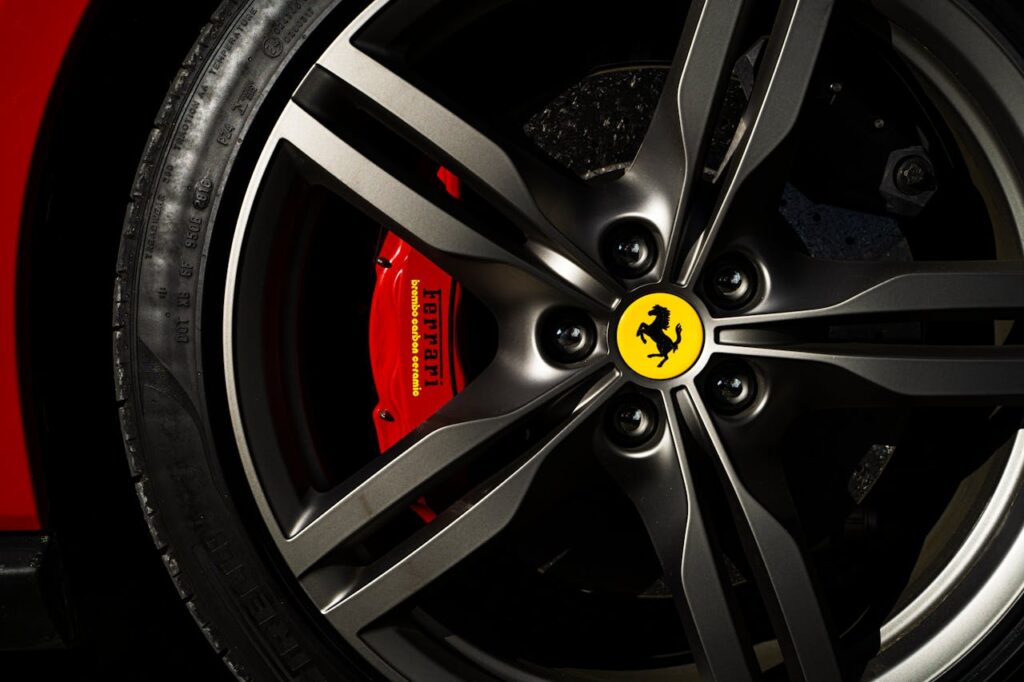 Detailed view of a Ferrari wheel and brake showcasing luxury automotive design.